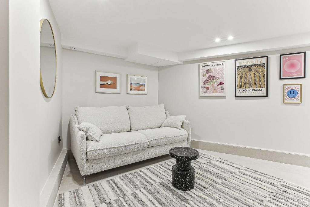 een woonkamer met een bank en een tapijt bij Maison atypique de 82 m2 sur 4 niveaux proche Saint Mande in Vincennes