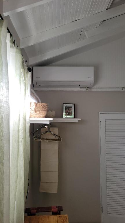 Green Monkey Cottage في Saint Lucy: غرفة بها ستارة ورف للمناشف