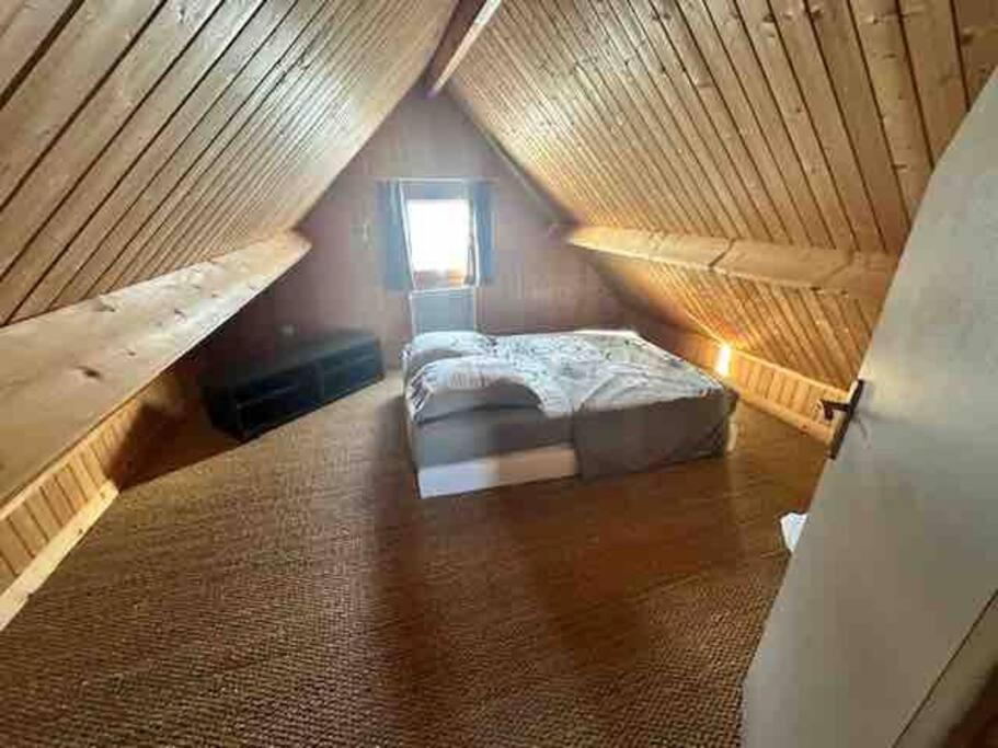 a bedroom with a bed in a attic at Chalet douillet 4 personnes -Proche plage in Merville-Franceville-Plage