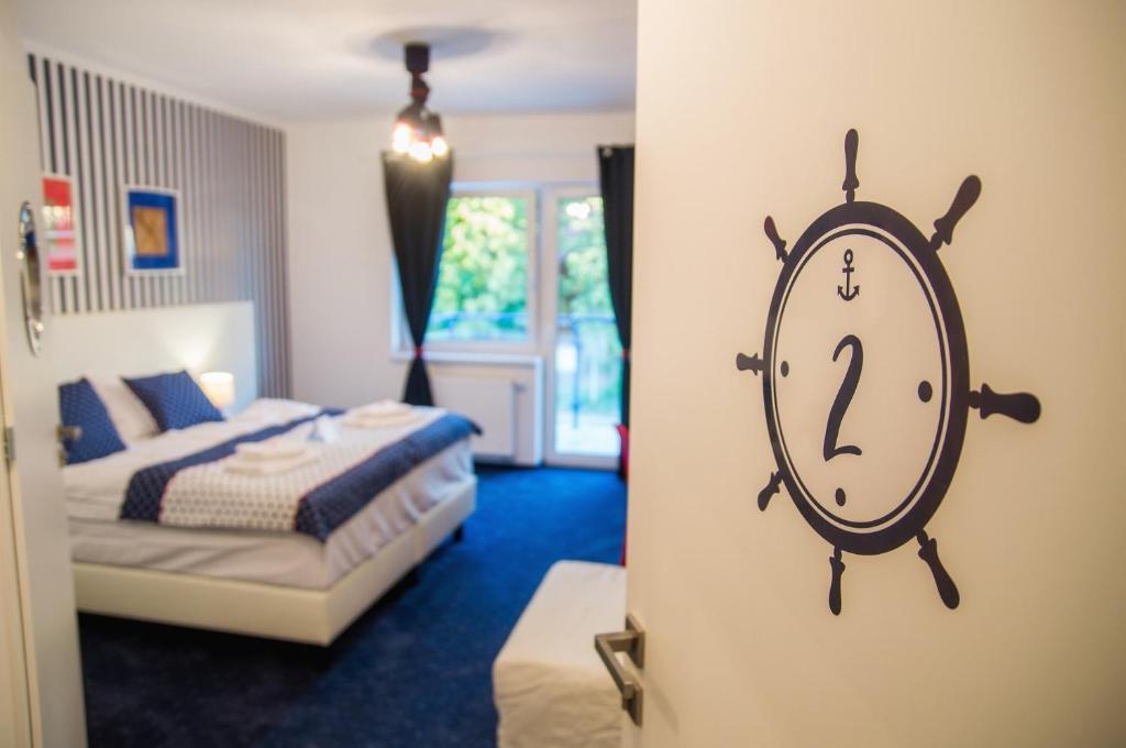 a bedroom with a bed and an alarm clock on the wall at Marina Mikołajki in Mikołajki