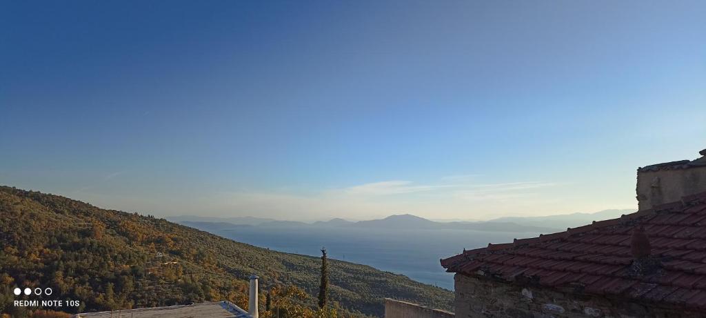 a view of the ocean from between two buildings at Rose Garden Cottage in Katochori