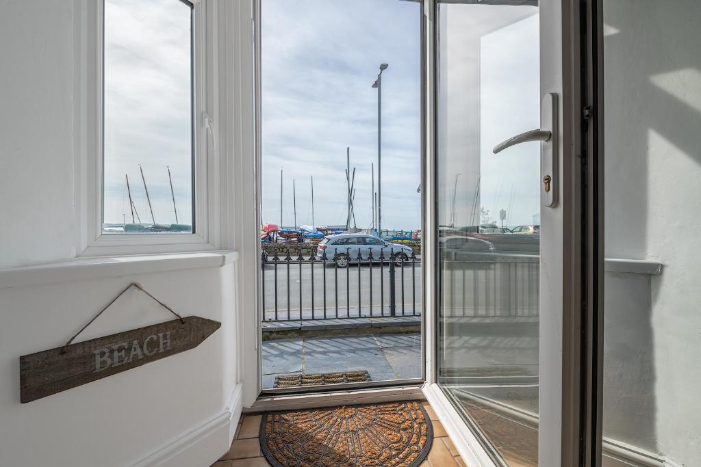 una puerta abierta a un balcón con vistas a un aparcamiento en 2 Bed Ground Floor Beach Location, en Aberdyfi