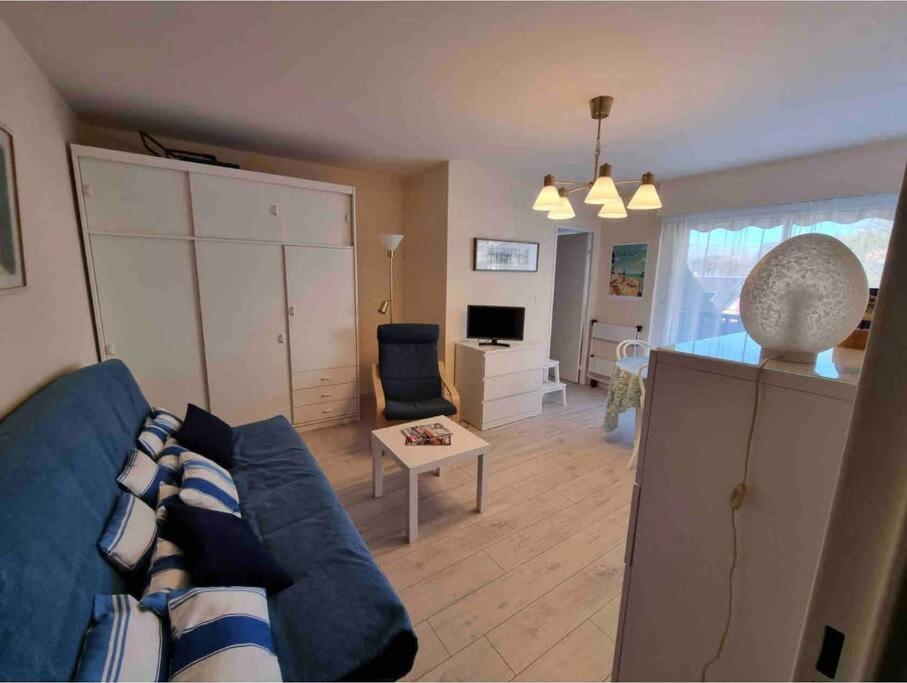 un salon avec un canapé bleu et une table dans l'établissement Athena Proche plage Centre cabourg, à Cabourg