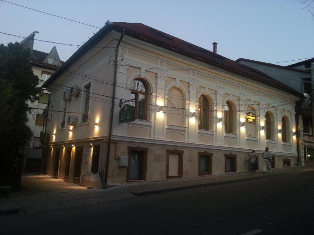 een groot wit gebouw waar mensen voor staan bij Vila Siago in Cluj-Napoca