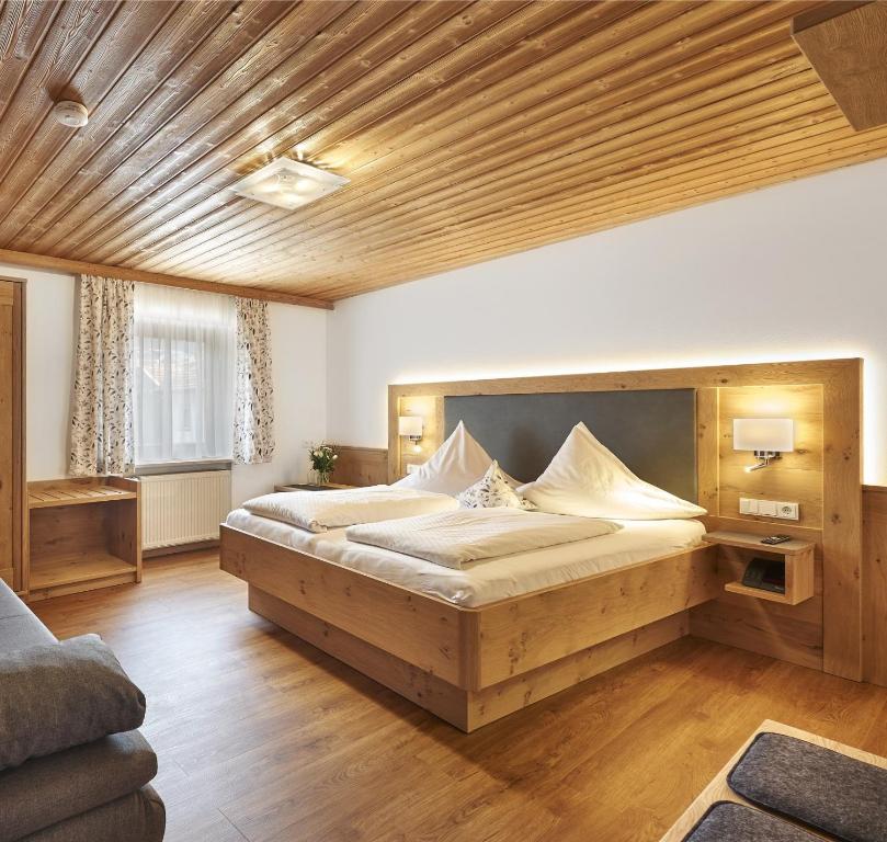 a bedroom with a large bed in a room at Pension Zum Rechen in Bodenmais