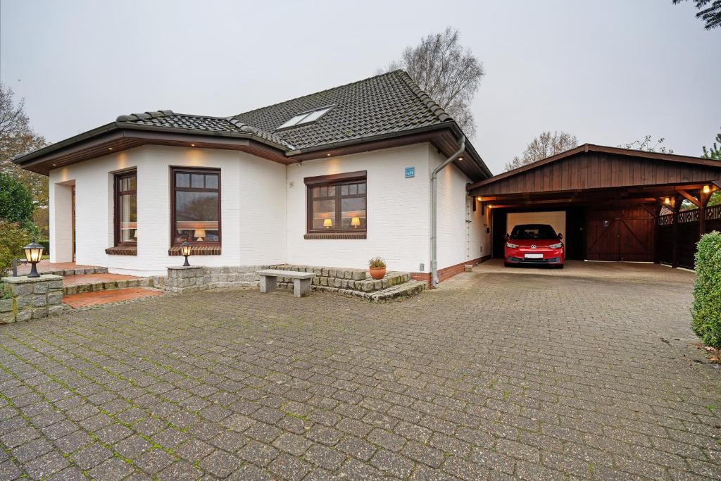 a white house with a car parked in front of it at Ferienwohnung Offenbüttel in Oldenbüttel