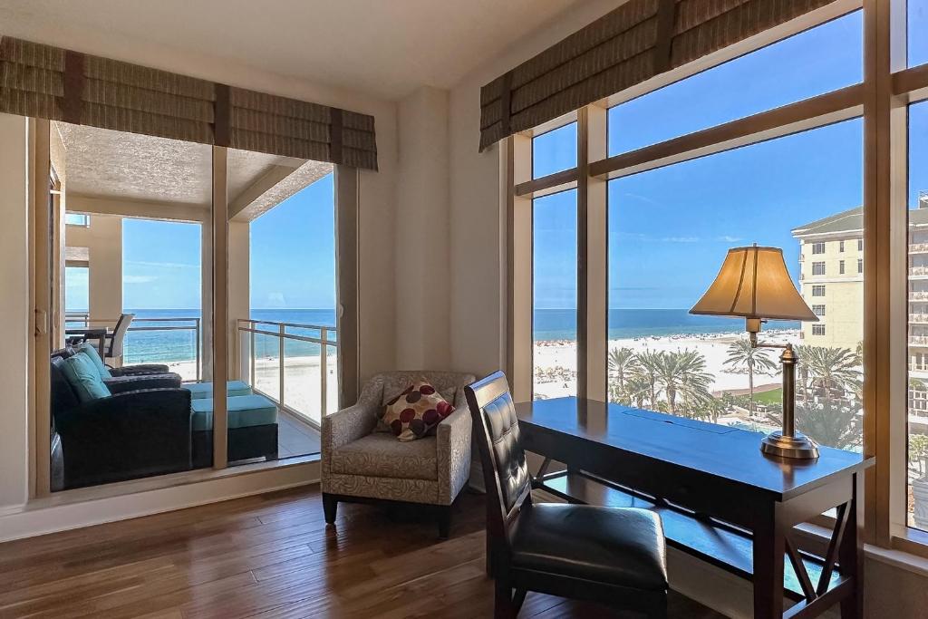a dining room with a desk and a view of the ocean at Sandpearl Residences 606 in Clearwater Beach