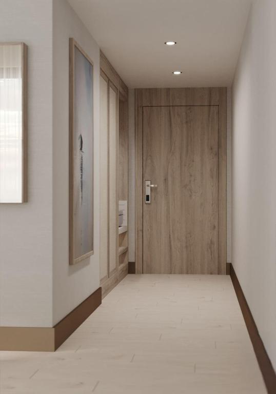 a hallway with a wooden door and white walls at Ducale Lara - Ultra All Inclusive in Lara