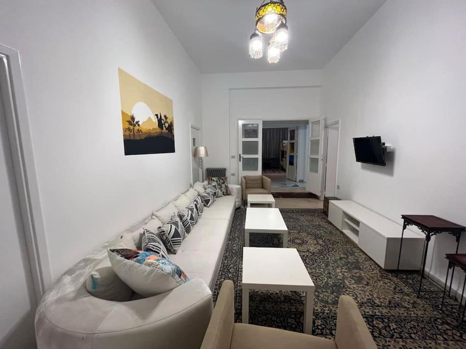 een woonkamer met banken en tafels en een televisie bij B Beitna in Amman