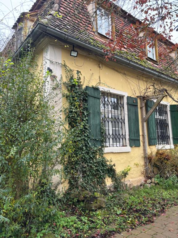 a yellow house with ivy growing on the side of it at Gutsherren Wohnung in Unterschwaningen