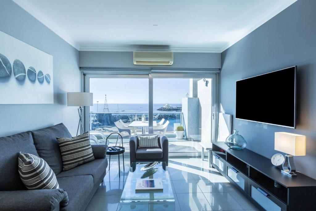 ein Wohnzimmer mit Sofa und Fernseher in der Unterkunft Teresita Mogamar Beachfront in Puerto de Mogán