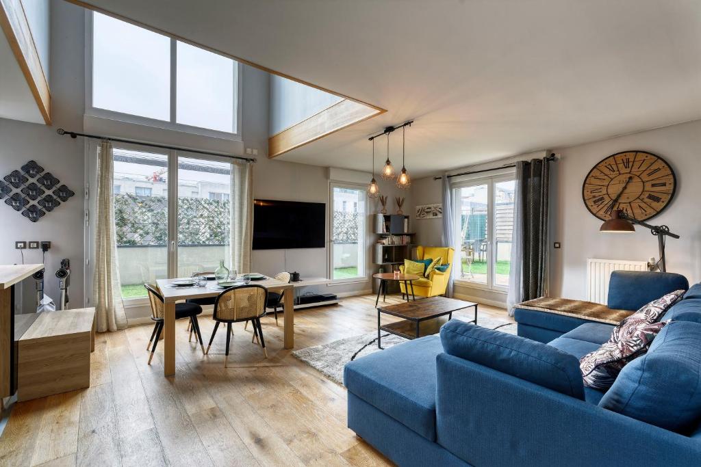 un salon avec un canapé bleu et une table dans l'établissement La Plume d'Hugo - Appt Duplex pour 8, à Saint-Ouen