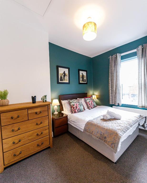 a bedroom with a bed and a dresser and a window at Bright and Well-Kept 3-Bed Property! Free Parking in Bishop Auckland