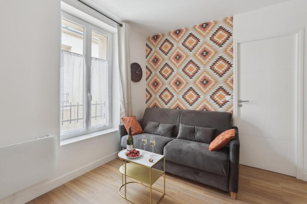 un salon avec un canapé et une fenêtre dans l'établissement 863 Suite Hortensia - Superbe Appartement, à Montreuil
