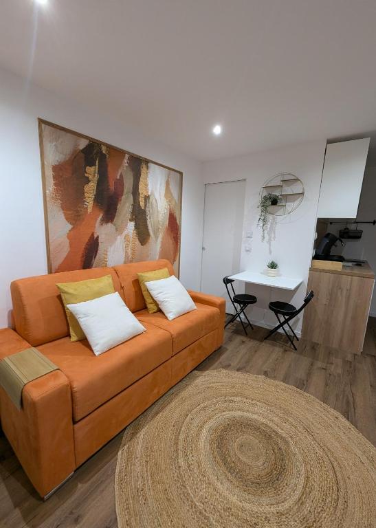 un salon avec un canapé et une table dans l'établissement Évasion Douceur, studio accueillant, près de Paris, à Villejuif