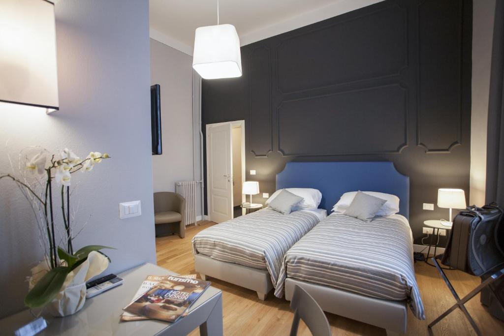a hotel room with two beds and a desk at Hotel Il Sole in Empoli