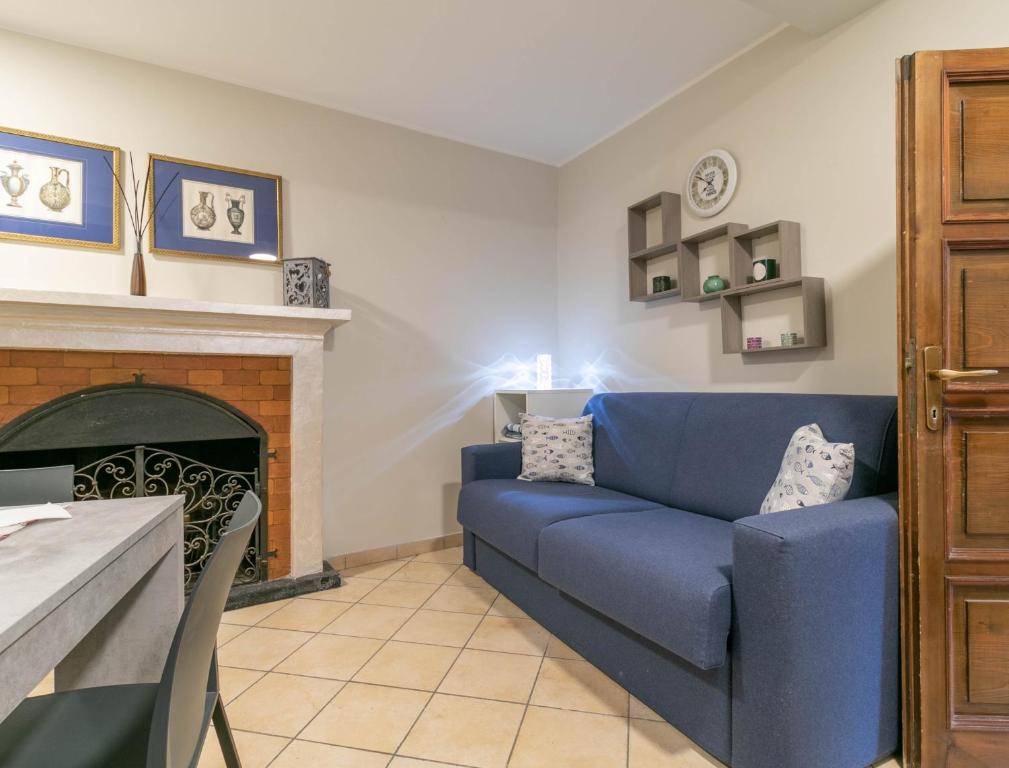a living room with a blue couch and a fireplace at A Due Passi dal Lago Welcomely in Tremezzo