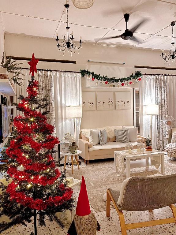 ein Weihnachtsbaum mitten im Wohnzimmer in der Unterkunft Cottage Near Lake Garden in Taiping
