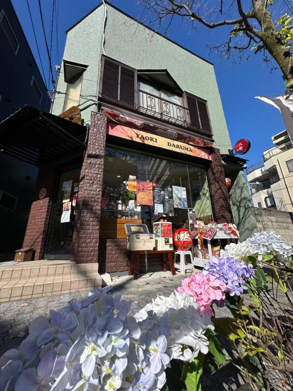 ein Laden mit Blumen vor einem Gebäude in der Unterkunft 青砥駅徒步5分 Aoto だるま宿 in Tokio