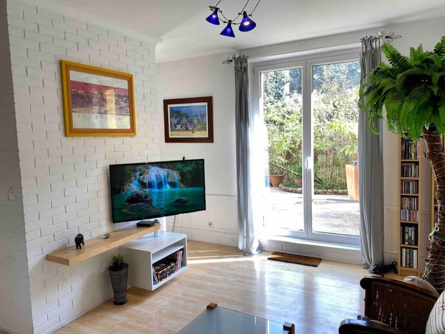 Televisyen dan/atau pusat hiburan di Calme et terrasse arborée en centre ville