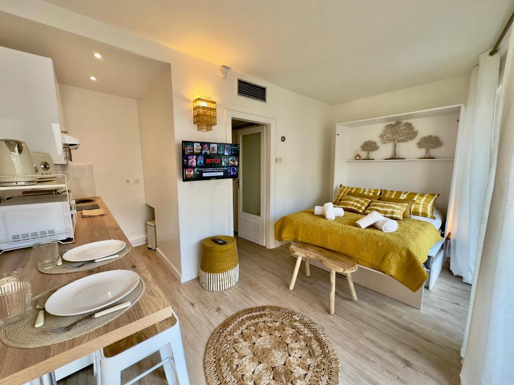 Cet appartement comprend une chambre avec un lit jaune et une cuisine. dans l'établissement L'Éclat Safran - Royal Luxembourg, à Nice