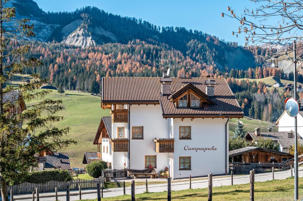 a house in the mountains with a fence at Apartments Campagnola in Badia