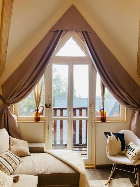 une chambre avec un lit et une grande fenêtre dans l'établissement Duplex en altitude, appartement au calme, aux Angles