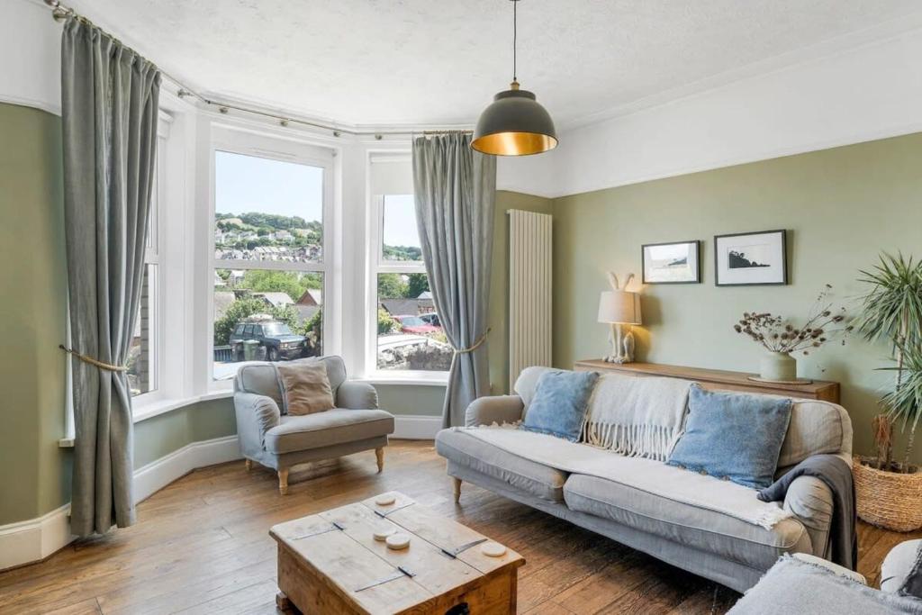 een woonkamer met een bank en een tafel bij Spacious House & Garden in Ilfracombe in Ilfracombe