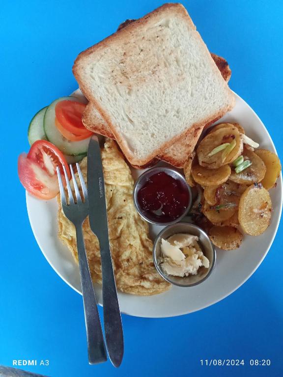 a plate of breakfast food with toast and fruit at Unique point home stay in Nagarkot