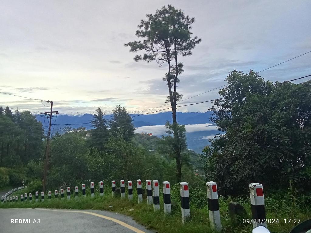 a road with a line of black and white poles at Unique point home stay in Nagarkot