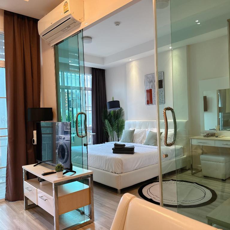 a bedroom with a bed and a tv and a mirror at Stylish room Near Central Fest in Chiang Mai