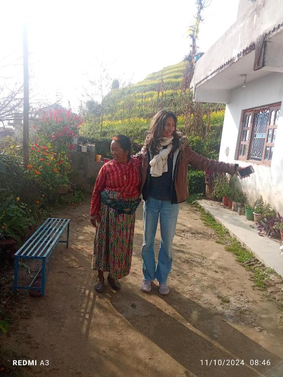 a woman standing next to a woman next to a bench at Unique point home stay in Nagarkot