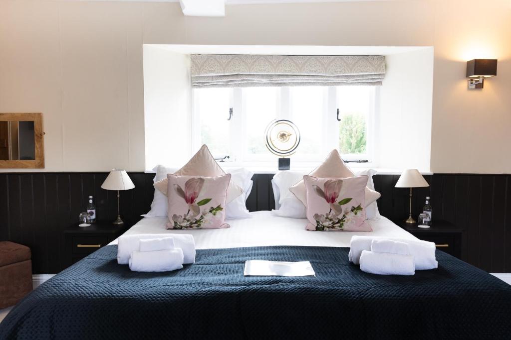 una camera da letto con un grande letto con cuscini rosa e bianchi di The Lighthouse a Frome