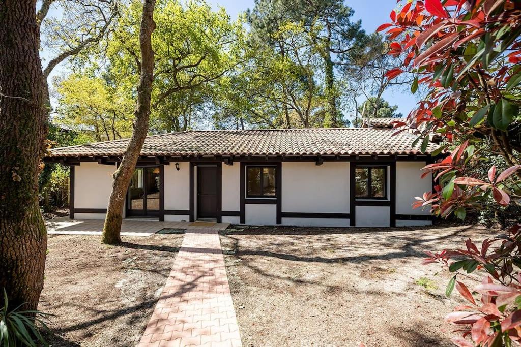 une maison avec une passerelle en briques devant elle dans l'établissement Villa Arbousière à deux pas de la plage PYLA SUR MER, à La Teste-de-Buch
