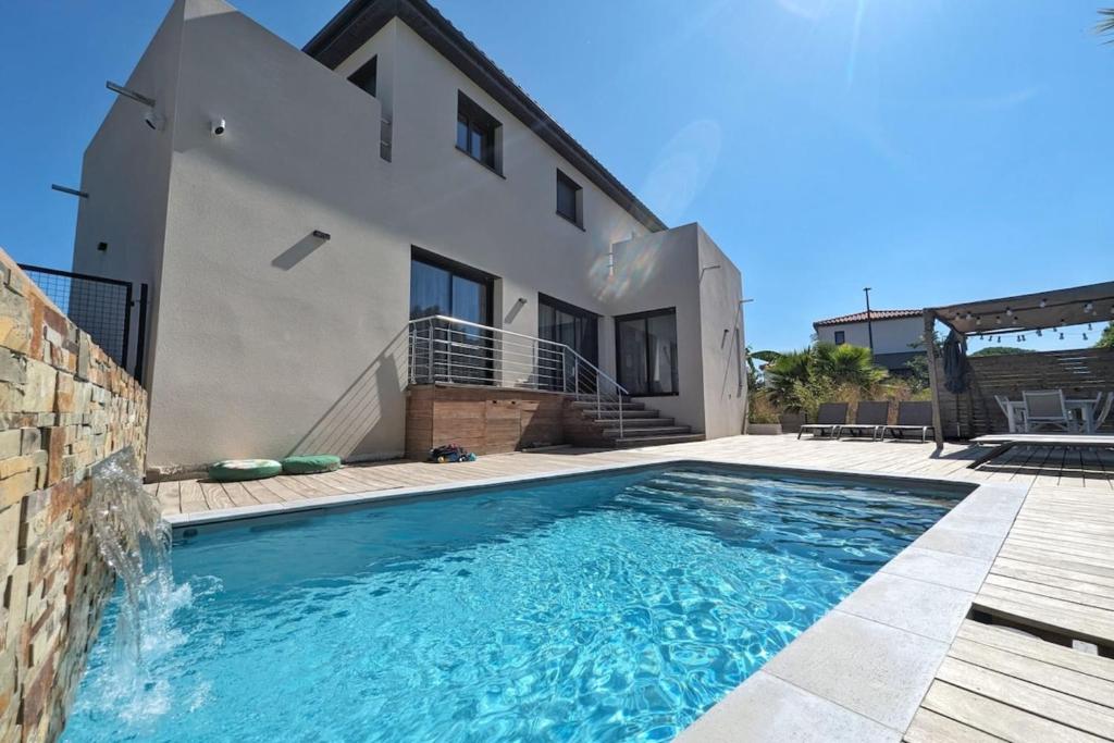 une maison avec une piscine devant une maison dans l'établissement La Salanque Villa Standing Piscine chauffée, à Villelongue-de-la-Salanque