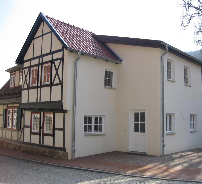 a white and black house with a brown roof at Harz Stolberg Ferienwohnung in Stolberg