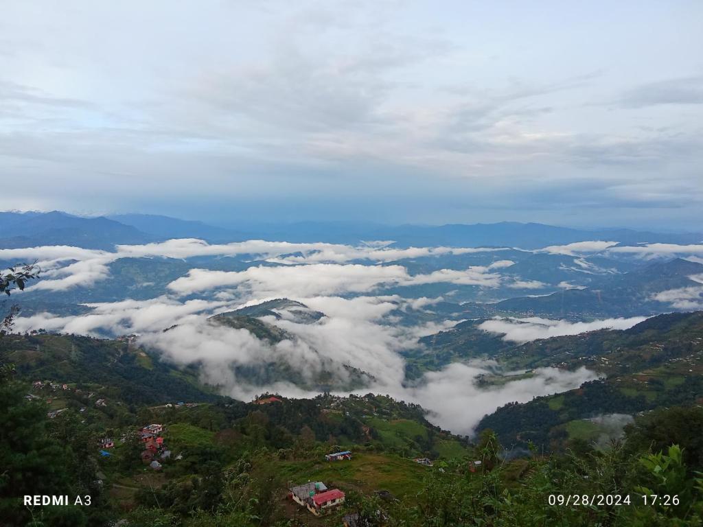 a view of a valley of clouds in the mountains at Unique point home stay in Nagarkot