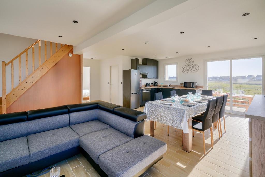 un salon avec un canapé bleu et une table dans l'établissement Séjour breton à 7 avec vue sur le phare d'Eckmühl, à Penmarcʼh