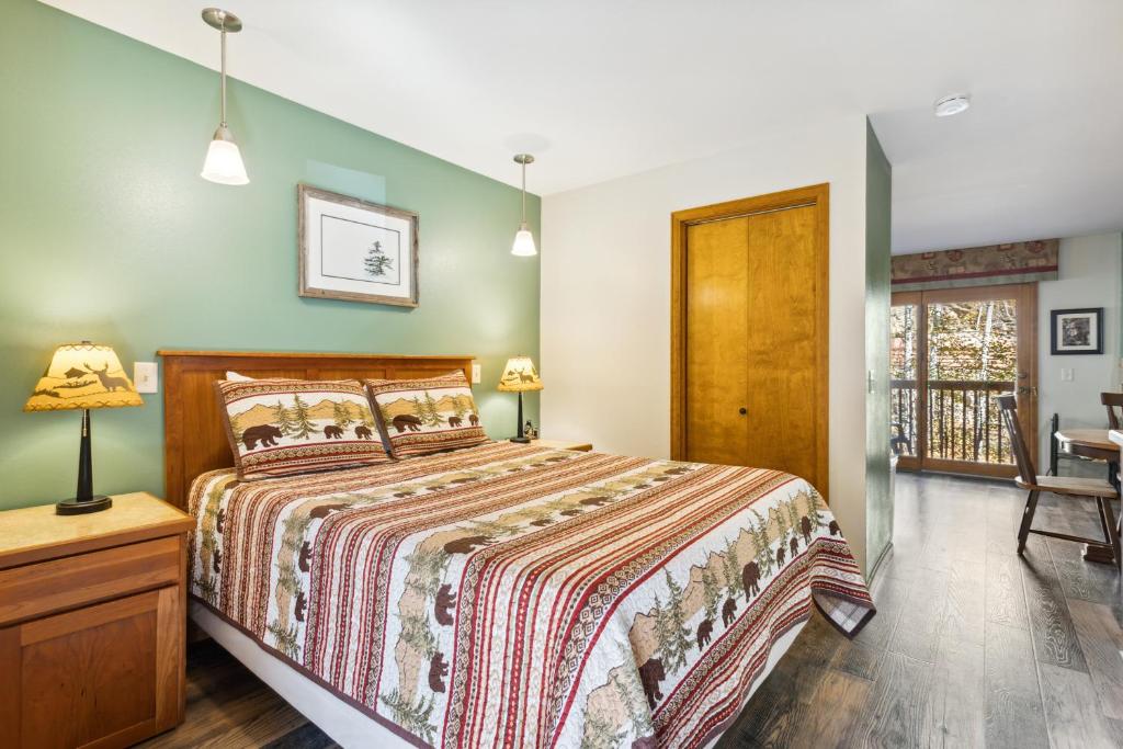 a bedroom with a bed and a table and a chair at Ponderosa Lodge in Estes Park