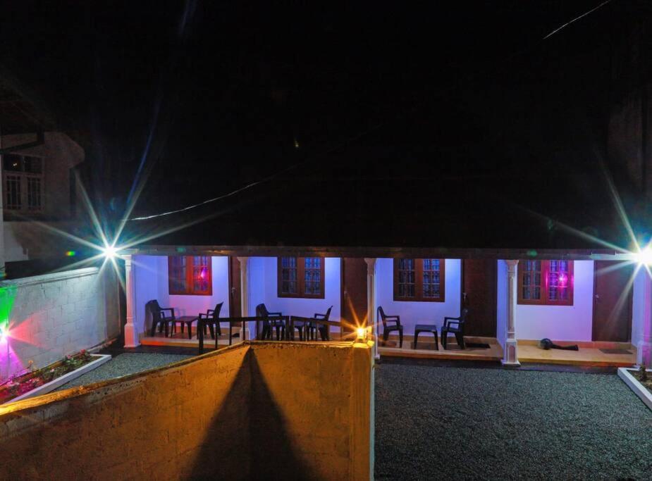 ein Haus mit einer Terrasse in der Nacht mit Lichtern in der Unterkunft Kildare Cottage in Nuwara Eliya