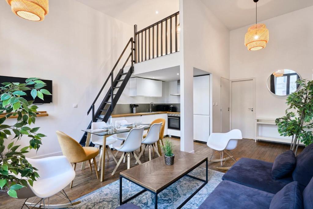 un salon avec un canapé bleu, une table et des chaises dans l'établissement Bright 3-bedroom 2-bathroom flat., à Lille