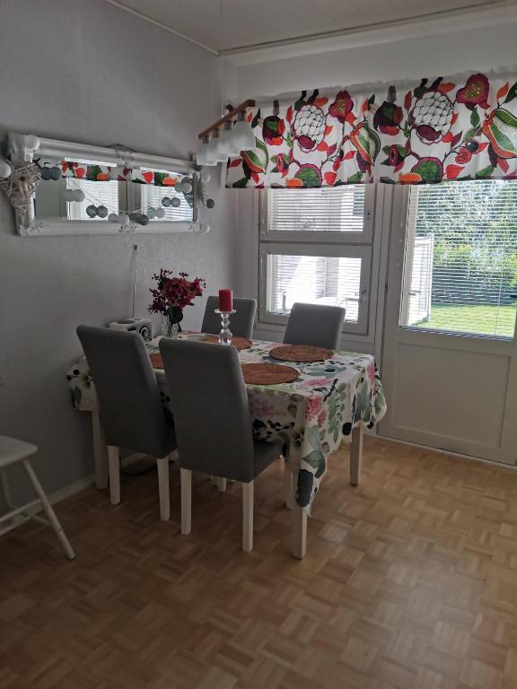 a dining room with a table and chairs and a window at Hirvikoto in Sotkamo
