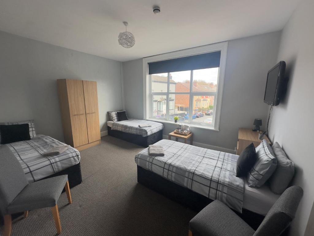 a room with a bedroom with a bed and a couch at The Prince Alfred Rooms in Liverpool