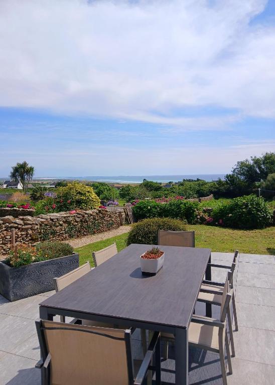 - une table noire avec des chaises et un bol dans l'établissement Les hortensias de papy, à Plozévet