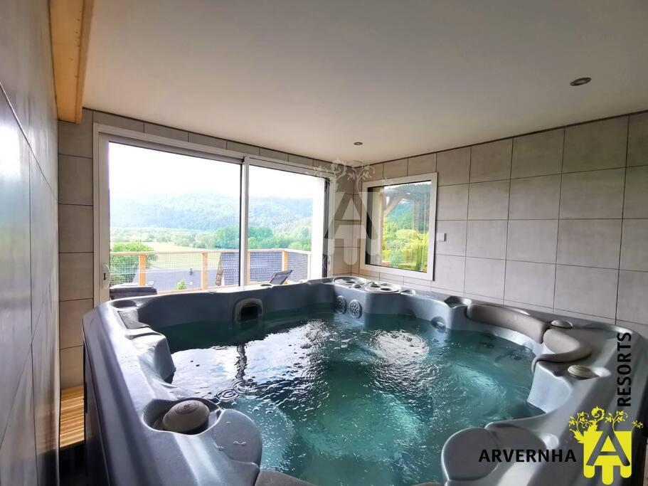 baño con bañera grande y ventana grande en Lona Spa, en Chambon-sur-Lac