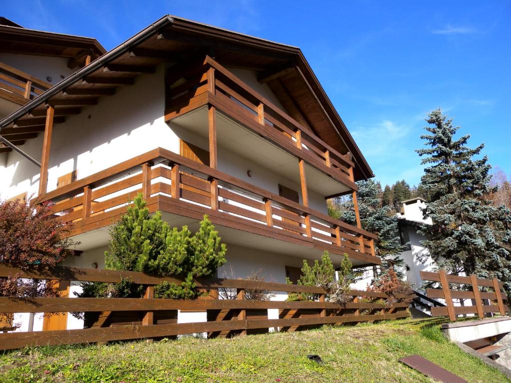 a house with a wooden fence in front of it at Appartamento Bellavista in Cavalese