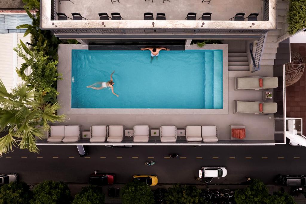 an overhead view of a person swimming in a pool at La Siesta Premium Saigon Central in Ho Chi Minh City