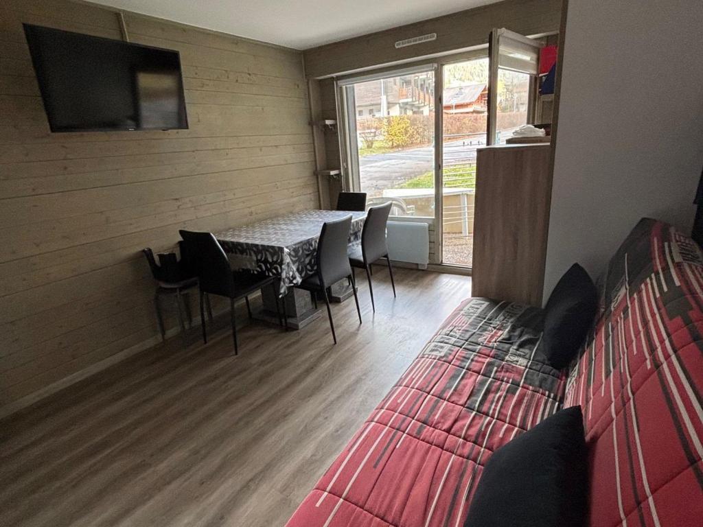 a room with a table and chairs and a tv at Studio au pied des pistes avec terrasse, parking et animaux acceptés! - FR-1-692-102 in La Chapelle-dʼAbondance