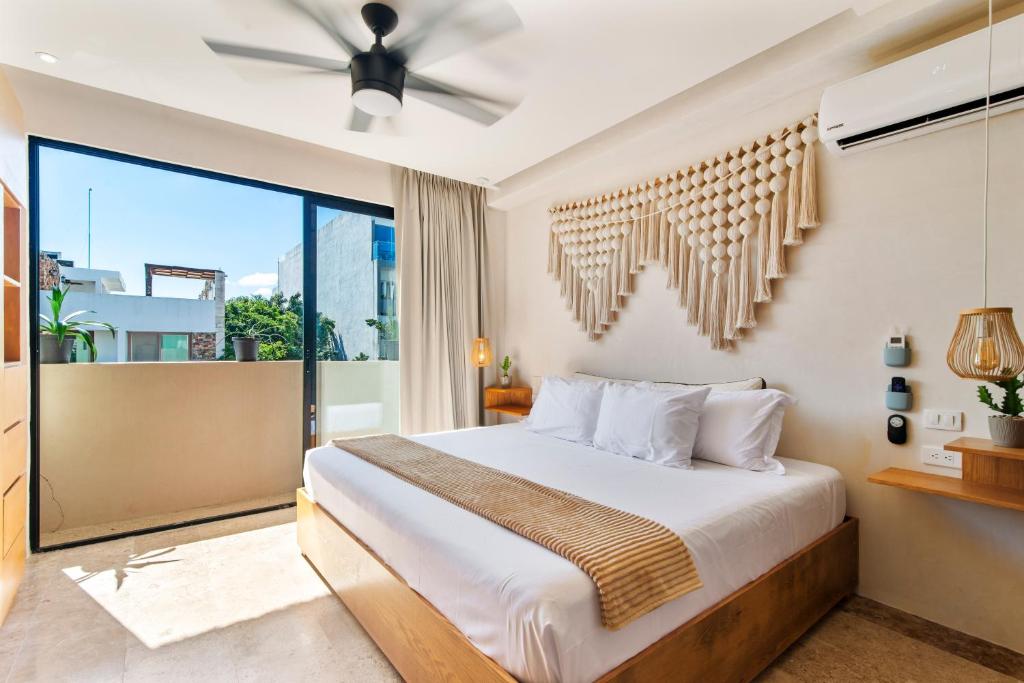 a bedroom with a bed and a large window at A Sweet Jungle Suite in Aldea Zama in Tulum