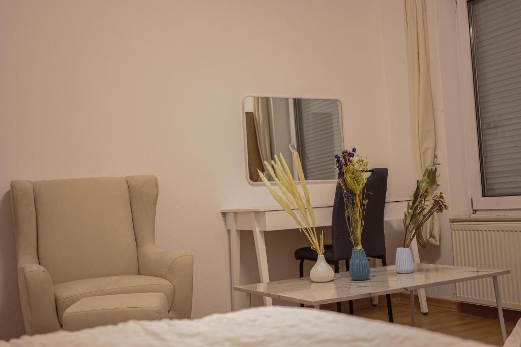 een woonkamer met een stoel en een tafel met een spiegel bij Bibo City Apartment in Bielefeld